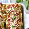 Vegan Spinach Lasagna Rolls with Almond Ricotta in white square baking dish