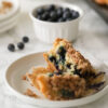Vegan Streusel Blueberry Muffin cut in half on white plate