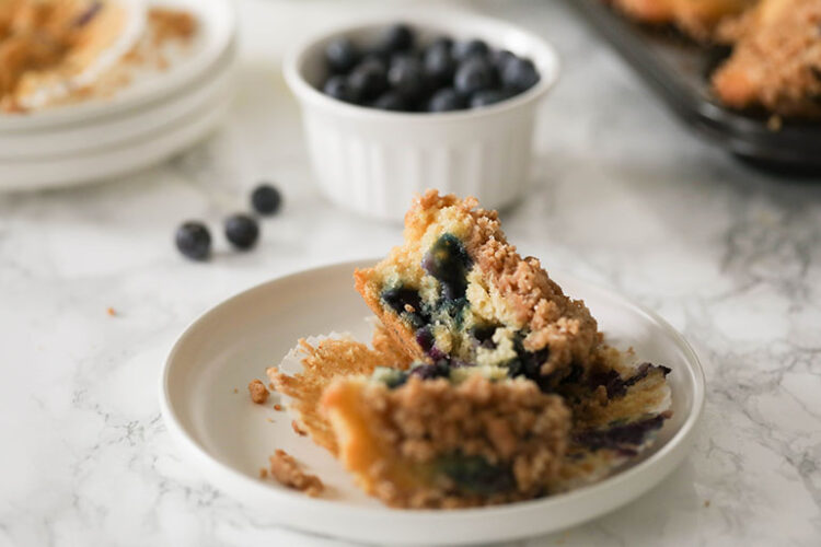 Vegan Streusel Blueberry Muffin cut in half on white plate