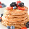 Stack of Whole Wheat Vegan Pancakes topped with fresh berries