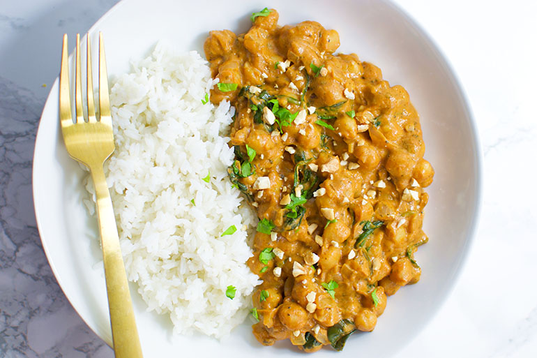 Chickpea Peanut Stew with gold fork and white bowl