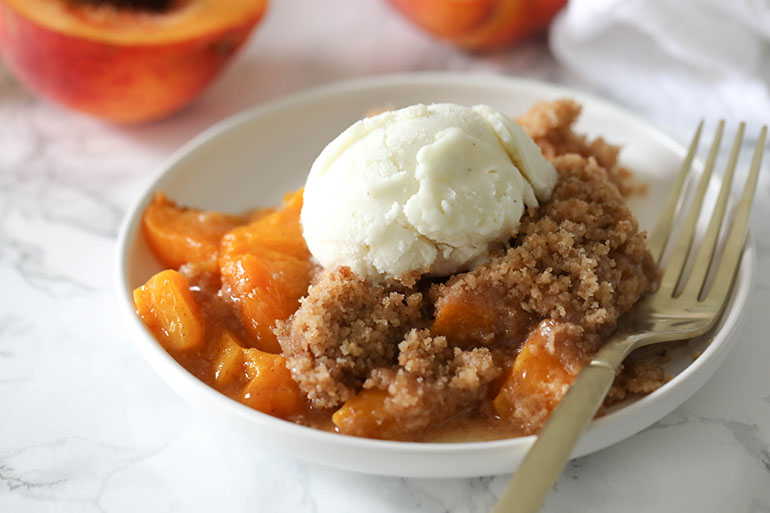 Vegan Peach Crisp with scoop of ice cream. 