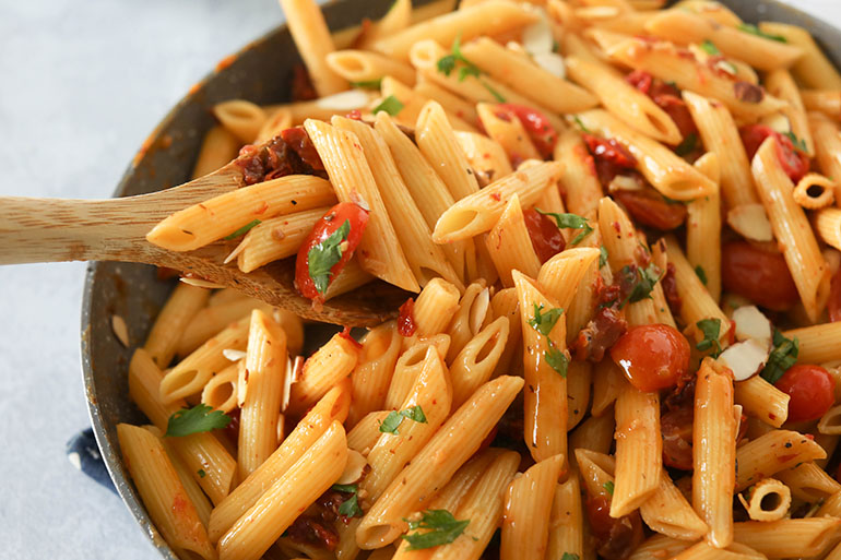 Vegan Sun Dried Tomato Pasta with wooden spoon