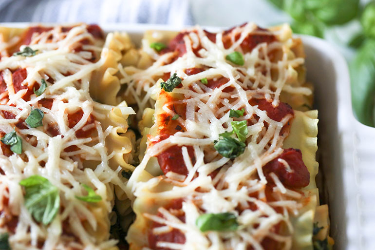 Vegan Spinach Lasagna Rolls with Almond Ricotta in white square baking dish