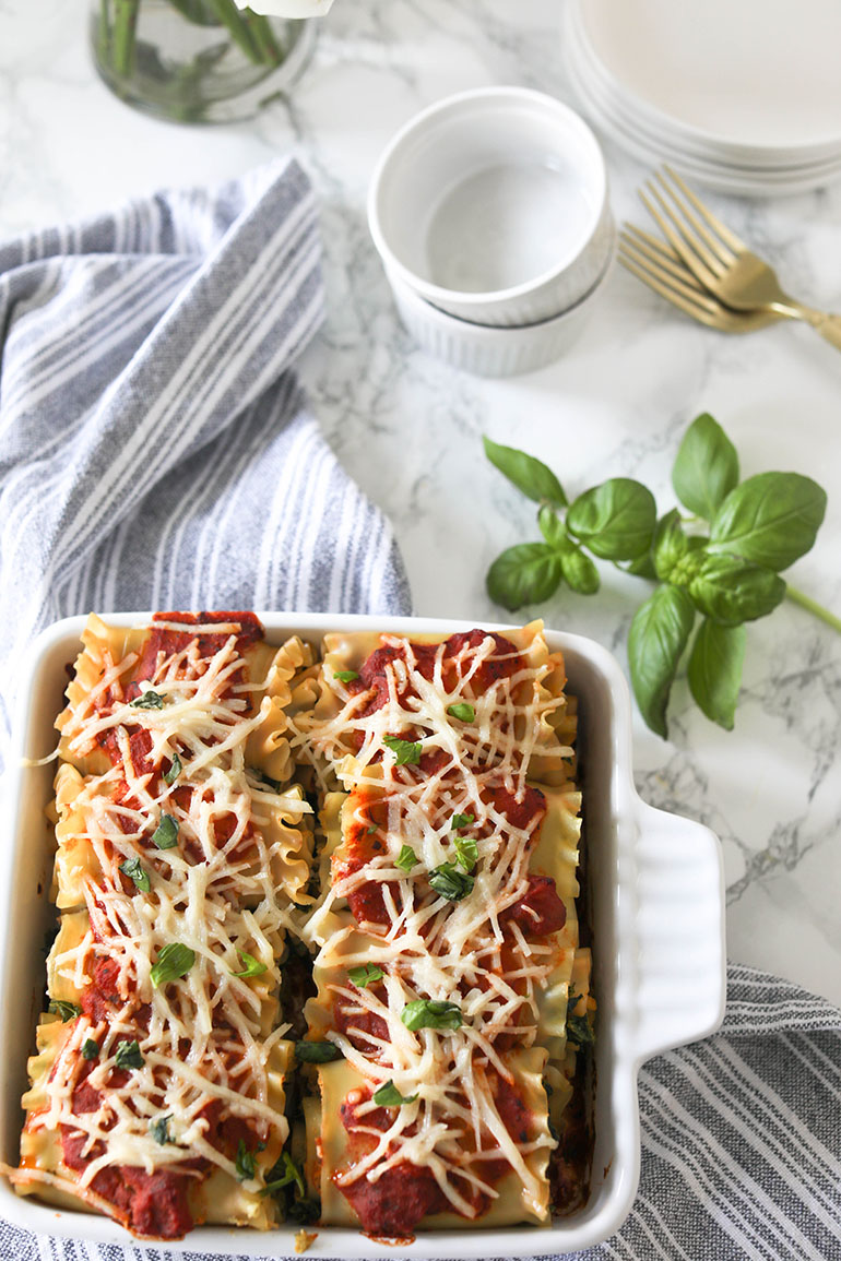 Vegan Spinach Lasagna Rolls with Almond Ricotta in white square baking dish