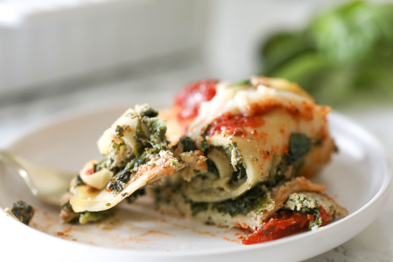 Vegan Spinach Lasagna Rolls with Almond Ricotta in white square baking dish