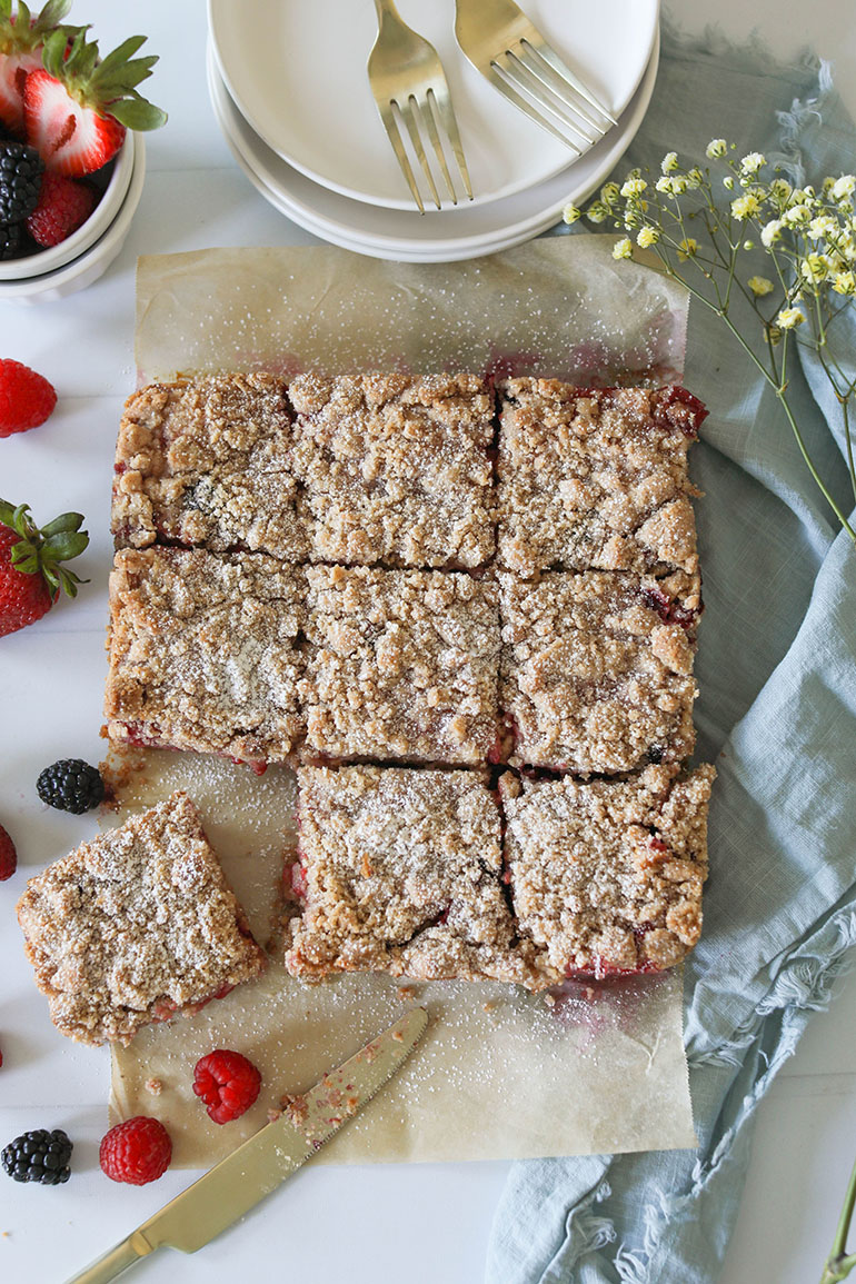 Vegan Triple Berry Crumb Bars on brown parchment paper