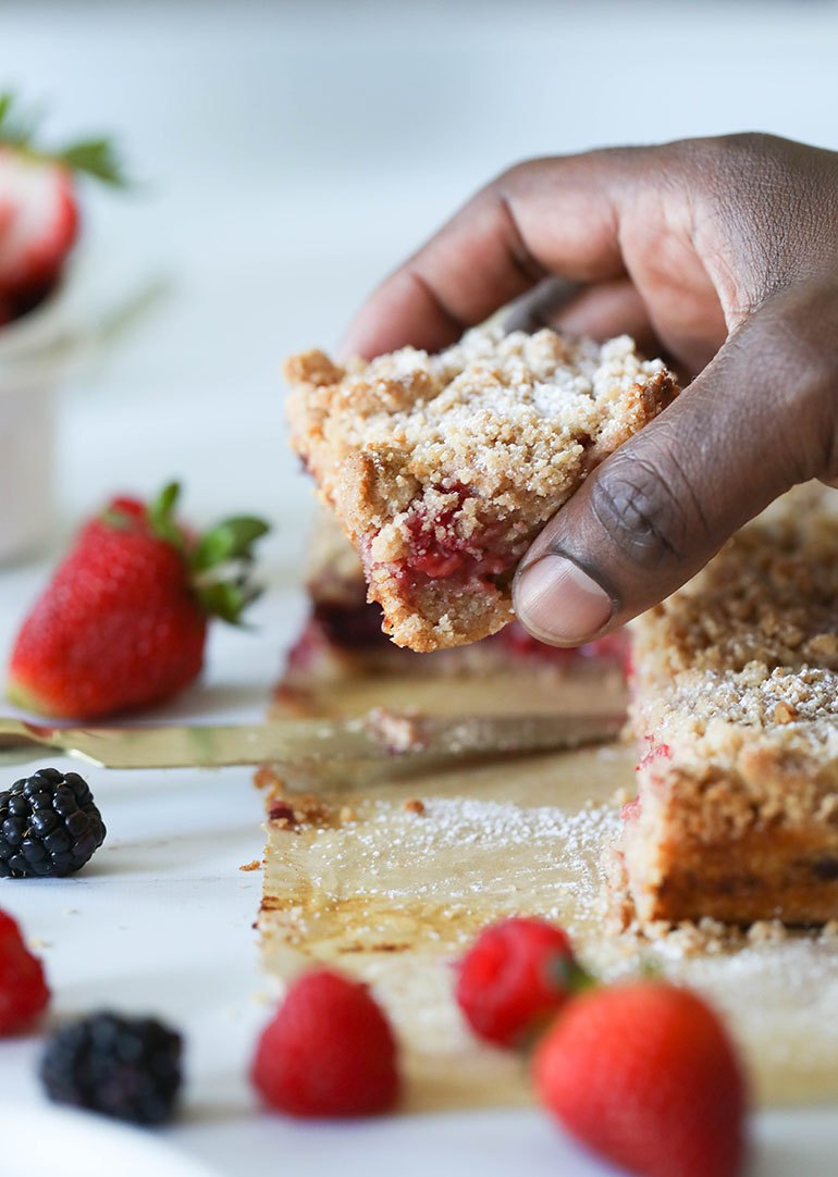 Vegan Triple Berry Crumb Bars on brown parchment paper