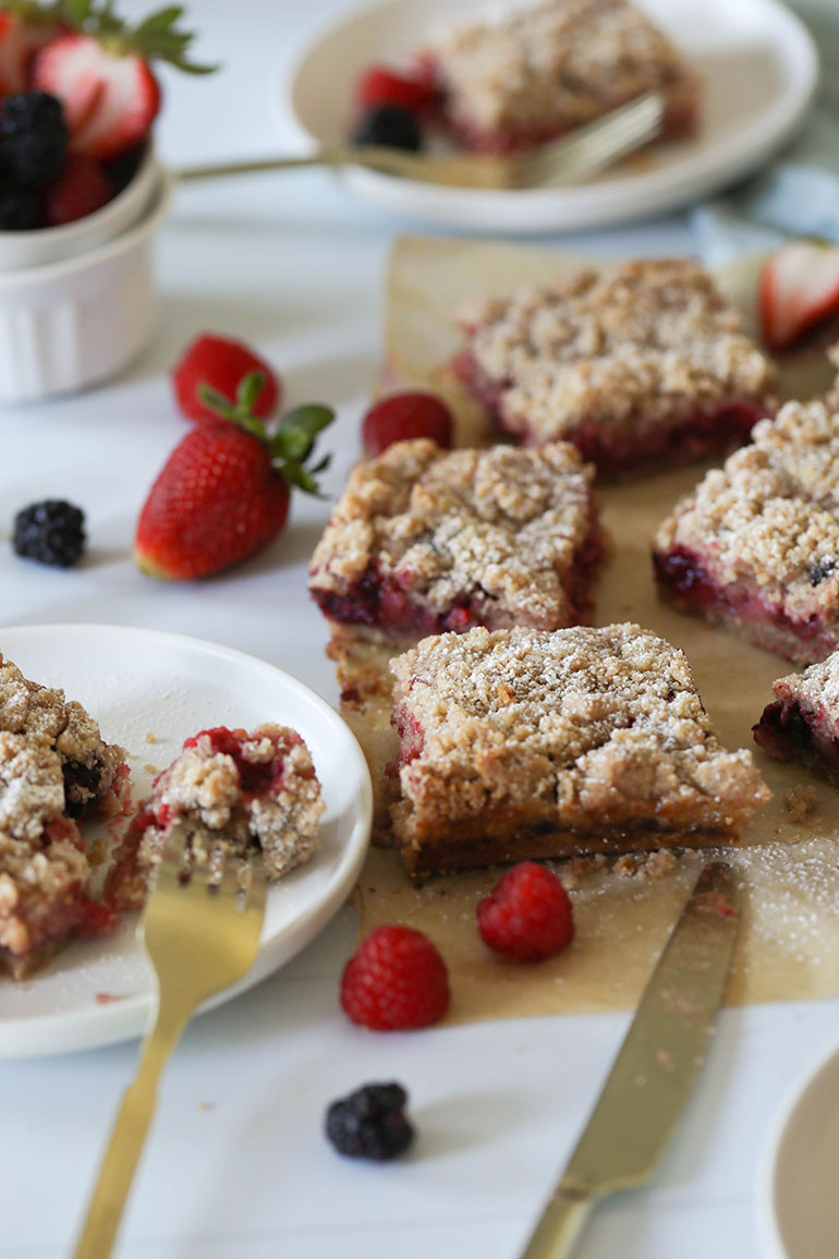 Vegan Triple Berry Crumb Bars on brown parchment paper