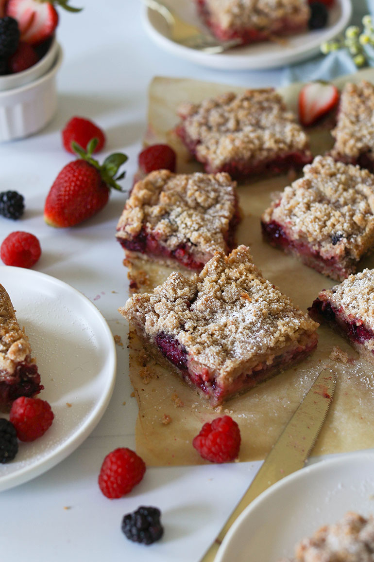 Vegan Triple Berry Crumb Bars on brown parchment paper