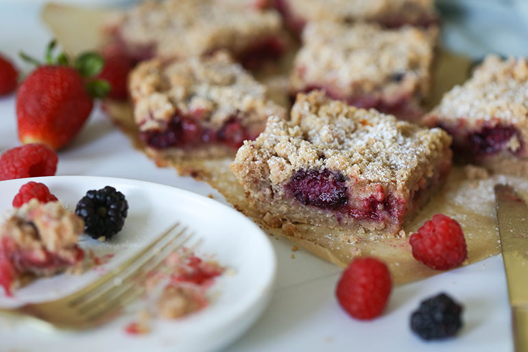 Vegan Triple Berry Crumb Bars on brown parchment paper