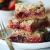 Stacked Vegan Triple Berry Crumb Bars on white plate