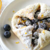 Vegan Blueberry Cream Cheese Danish on white plate with blueberries on the side