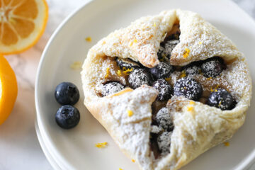 Vegan Blueberry Cream Cheese Danish on white plate with blueberries on the side