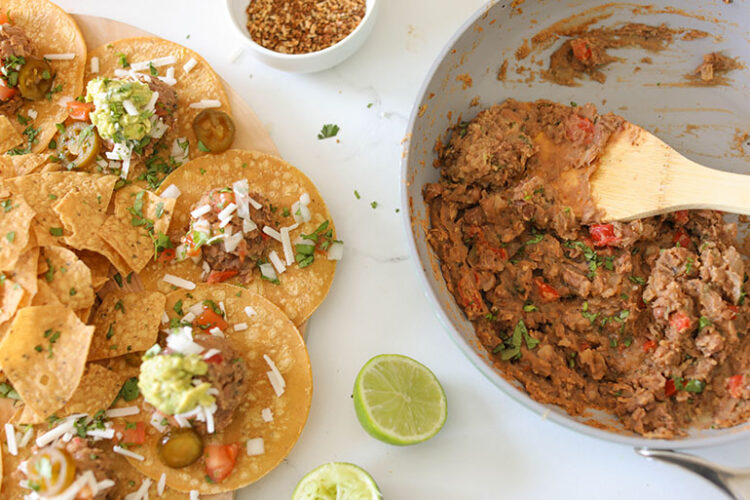 Vegan Refried Beans in pan with tacos